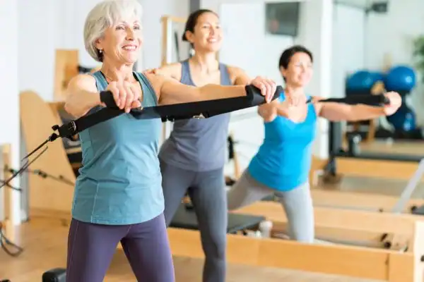 Toning Arms After 60: Empowering Womens Fitness Through Effective Weight Training 2 older woman doing weight training Burgess Hill and resistance in the gym to tone upper arms